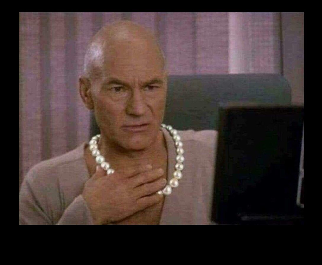 Jean Luc Picard wearing a pearl necklace, sitting at a computer with a look of dramatic concern